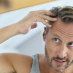middle-aged-man-concerned-by-hair-loss-grey-hair-irritated-goodluzs
