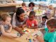 Teacher And Pupils Using Wooden Shapes In Montessori School