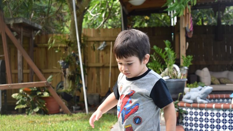 Boys playing outdoors on bikes in a garden