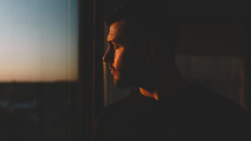 Man standing by a window in quiet contemplation